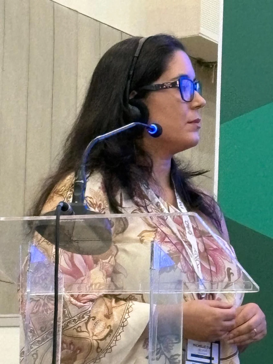 Dra. Michelle Dias falando ao microfone em congresso